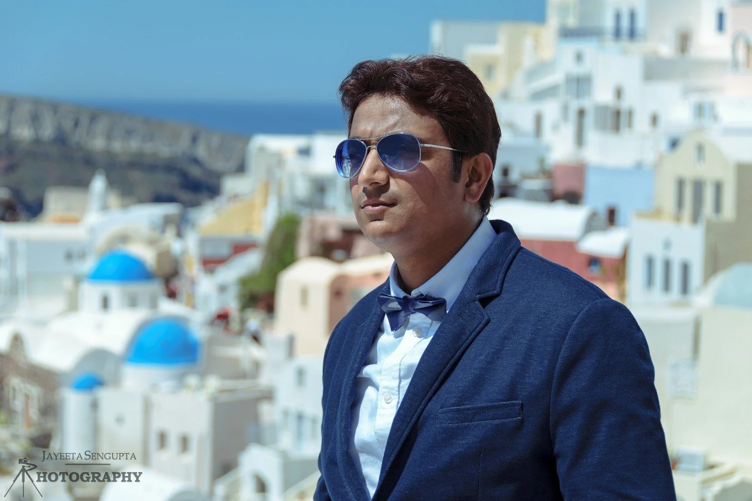 man standing near white houses church blue domes oia imerovigli firostefani fira village santorini greece caldera volcanic island