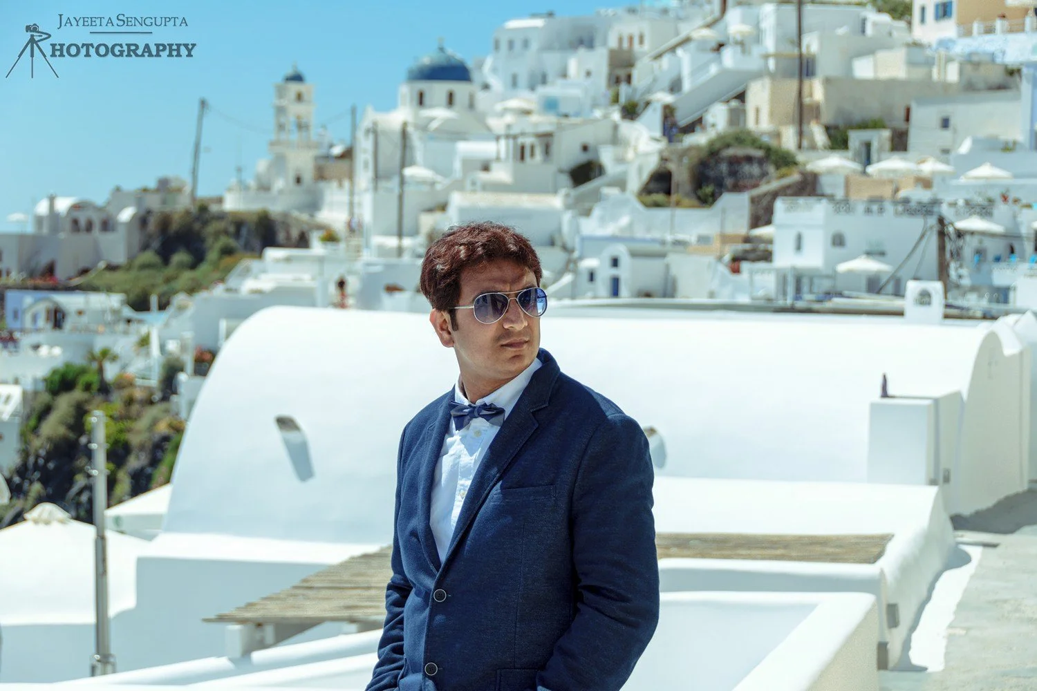 man standing near white houses church blue domes oia imerovigli firostefani fira village santorini greece caldera volcanic island