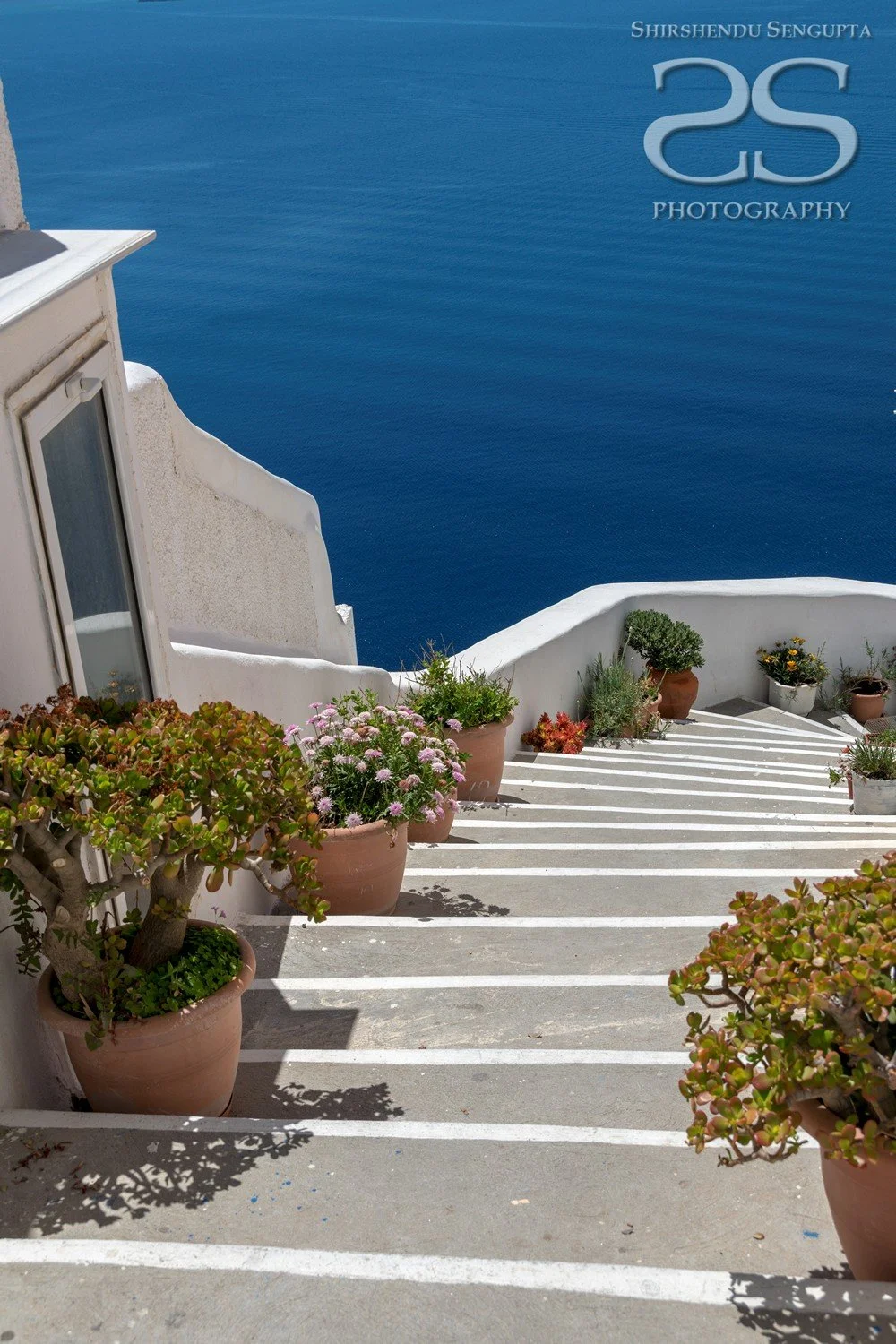 stairs going down to the sea near white houses church bell towers blue domes oia imerovigli firostefani fira village santorini greece caldera volcanic island
