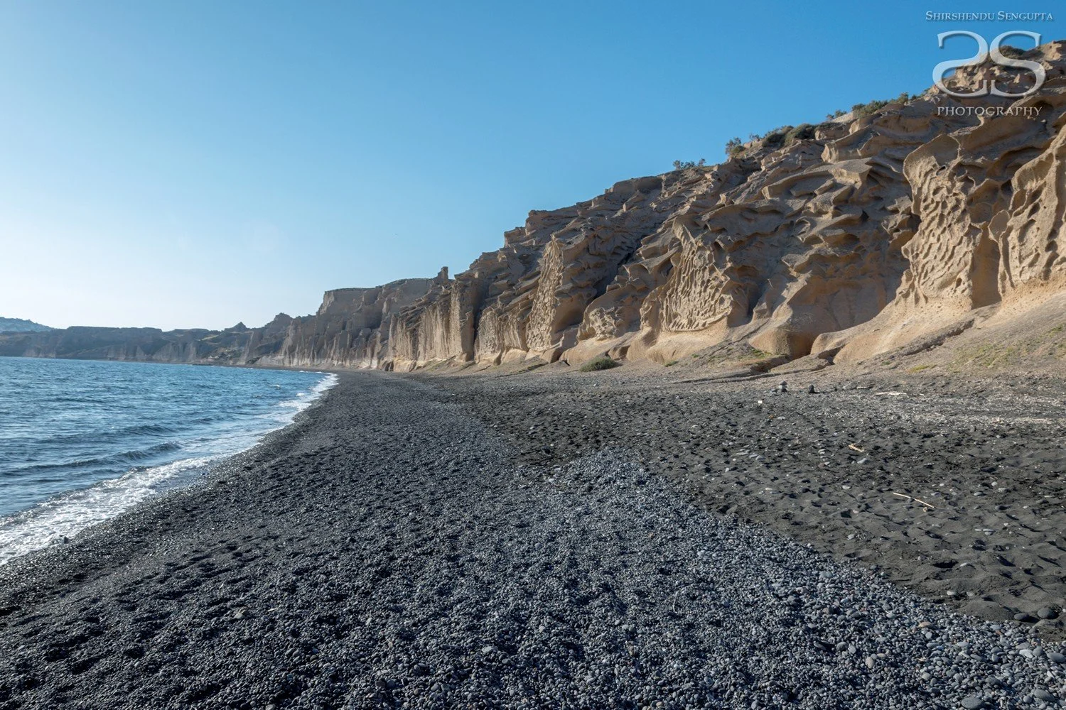 black beach with limestone rock formation vlychada in satorini island greece